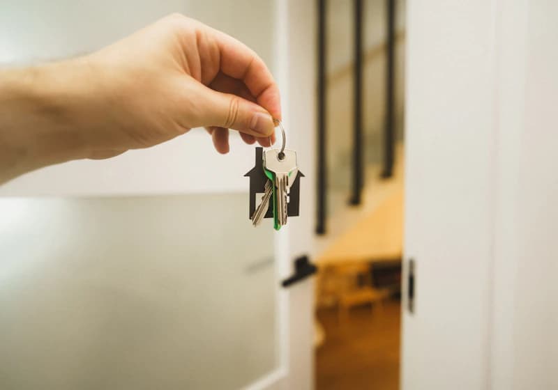 Hand inserting a key into a front door lock