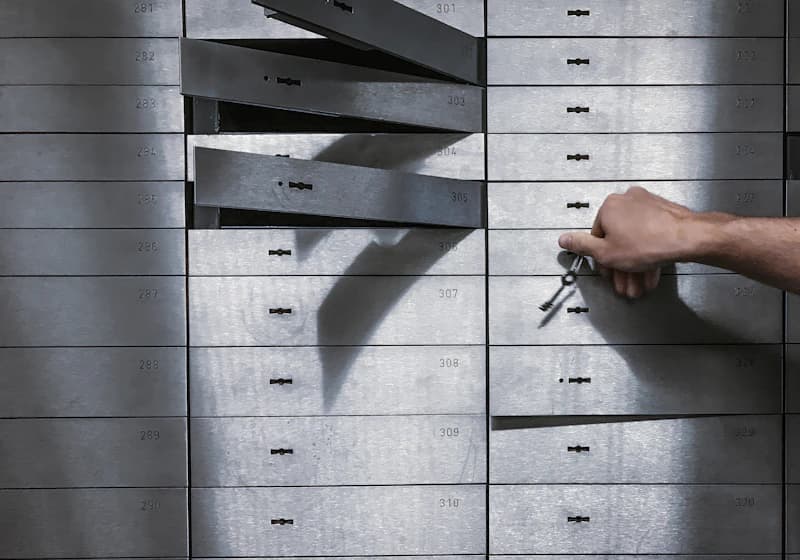 Hand using a key to open a safe deposit box