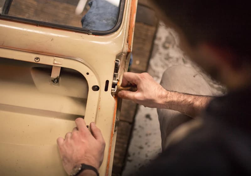Locksmith working on a car door lock mechanism
